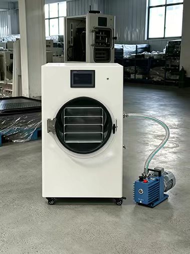 Geliss home vacuum freeze dryer factory front view - sleek white countertop lyophilizer unit with a digital touchscreen display panel placed next to its blue dual-stage vacuum pump setup